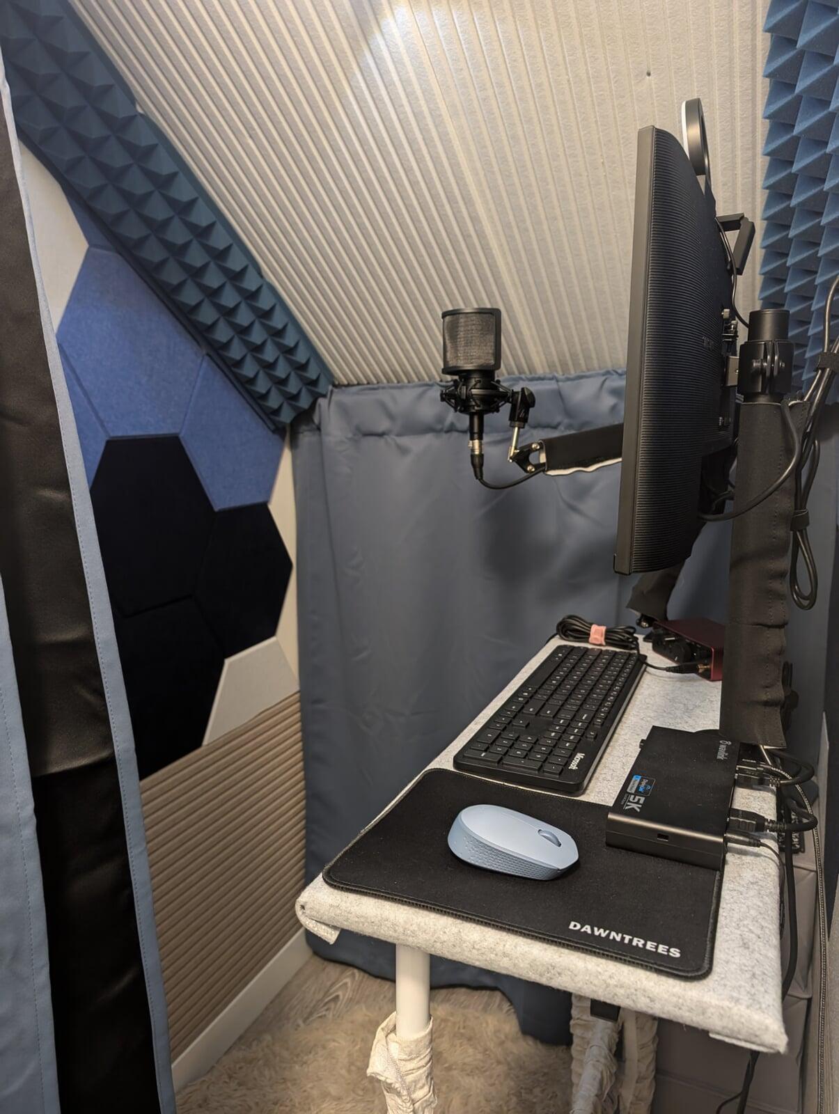 A small home recording studio complete with professional microphone, audio interface, studio headphones, and monitor.